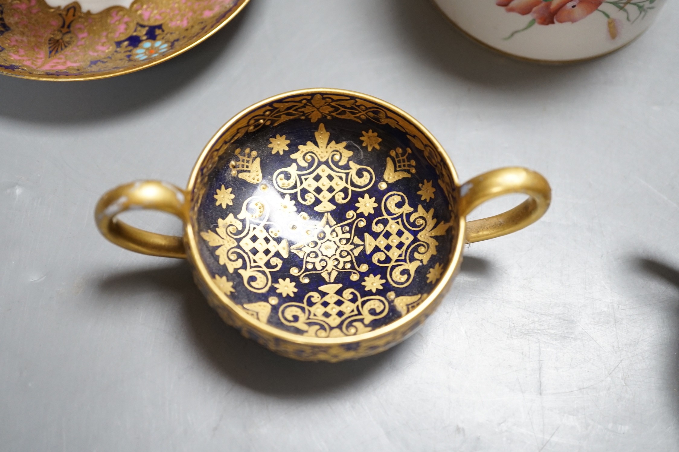 A 19th century Coalport fan shaped dish painted with a Loch scene, two small cup with twin handles decorated with raised gilding on a cobalt blue ground with crown marks, a Copeland jewelled cup and saucer with blue grou